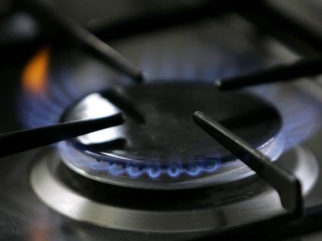 A gas-lit flame burns on a natural gas stove