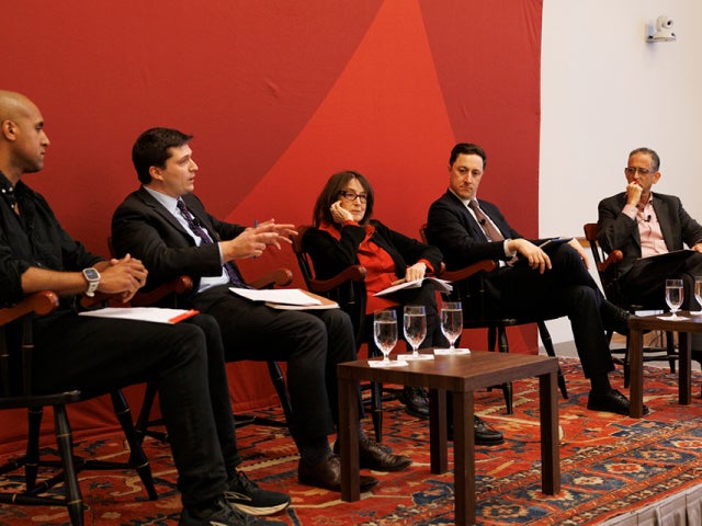 Five panelists sit on stage