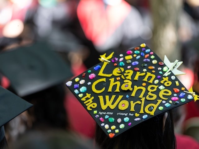 Graduation cap decorated with colorful gems and the message “Learn to Change the World”