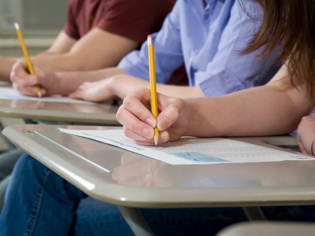 Students seated at desks fill out standardized test sheets with pencils.