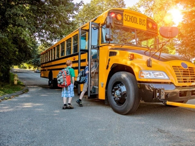 Children board a yellow school bus