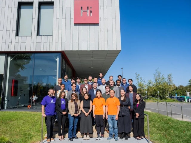A group of people gather in front of the Harvard Innovation Labs building