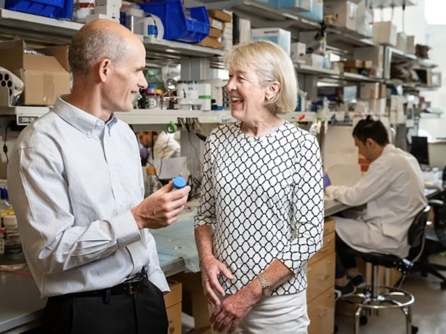 A patient speaks with researcher in the lab.