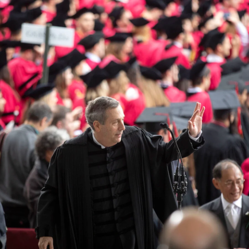 Larry Bacow waves at Harvard Commencement