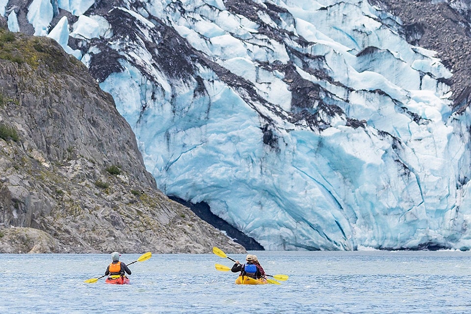 kayakers against glacier