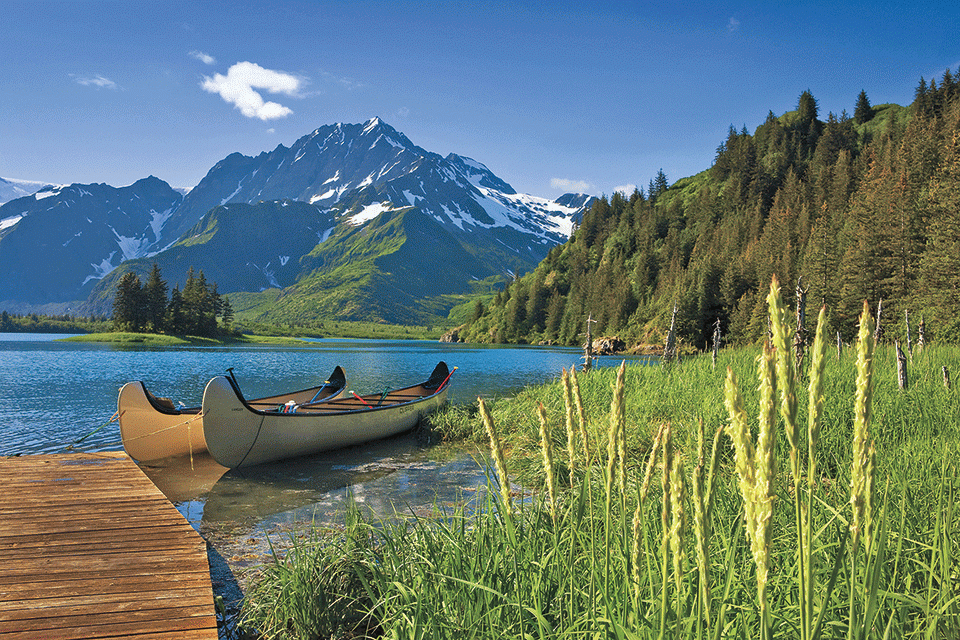 canoes on lake in front of mountain