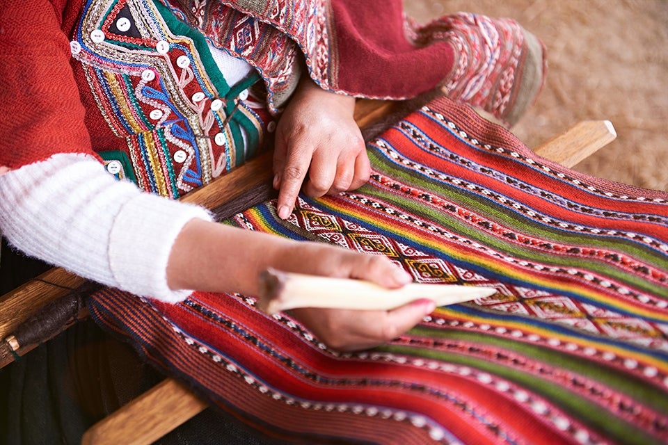 Peruvian woman making alpaca wool