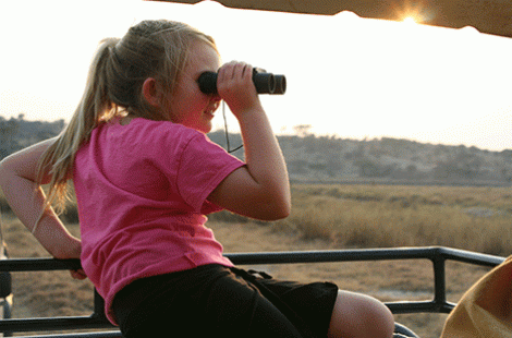 little girl looking through binocculars